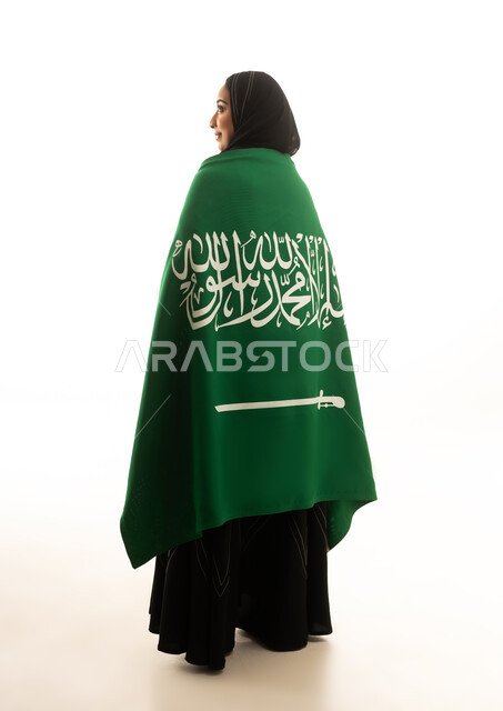 امرأة سعودية تحمل العلم الوطني على خلفية بيضاء