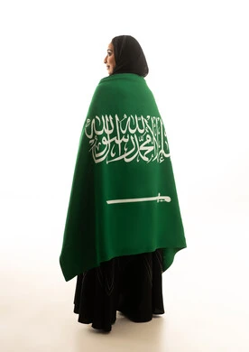 امرأة سعودية تحمل العلم الوطني على خلفية بيضاء