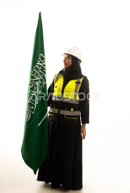 مهندسة سعودية تحمل العلم السعودي على خلفية بيضاء