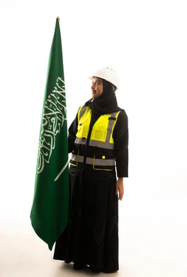 مهندسة سعودية تحمل العلم السعودي على خلفية بيضاء