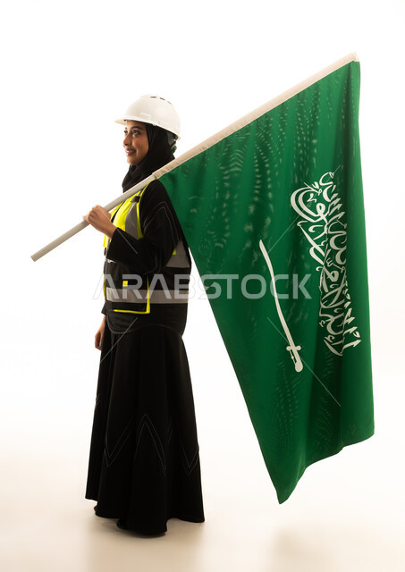 مهندسة سعودية تحمل العلم الوطني بخلفية بيضاء
