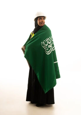 مهندسة سعودية بالعلم الوطني وخوذة العمل