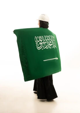 مهندسة سعودية بالعلم الوطني على خلفية بيضاء