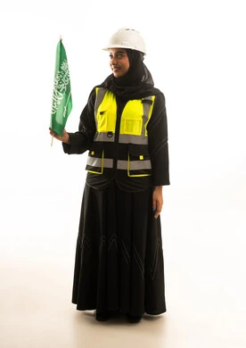 مهندسة سعودية تحمل العلم الوطني بزي العمل