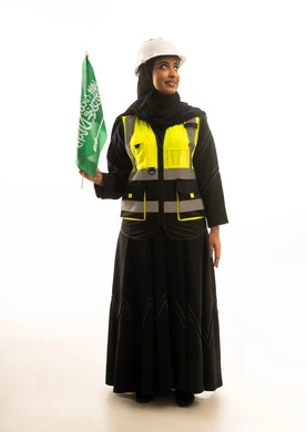 مهندسة سعودية تحمل العلم الوطني على خلفية بيضاء