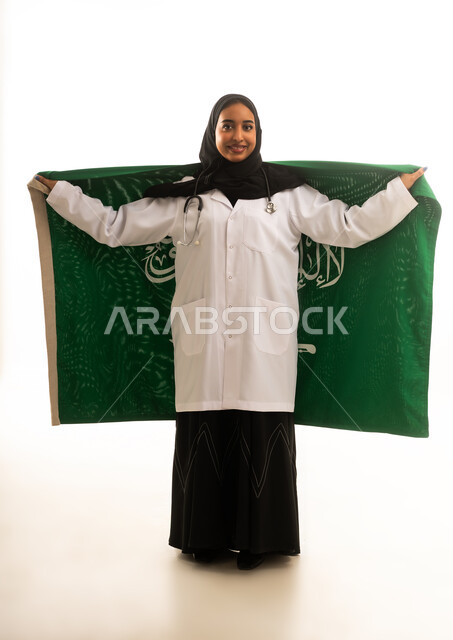 طبيبة سعودية تحمل علم المملكة العربية السعودية