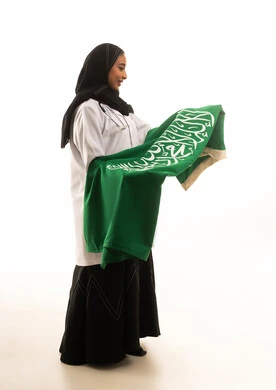 طبيبة سعودية تحمل علم المملكة على خلفية بيضاء