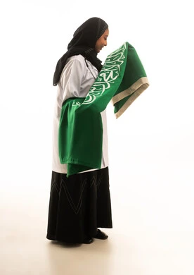 طبيبة سعودية تحمل العلم السعودي بخلفية بيضاء