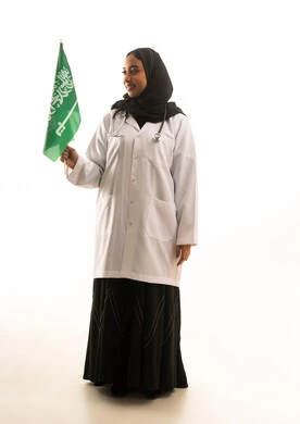 طبيبة سعودية تحمل العلم الوطني خلفية بيضاء
