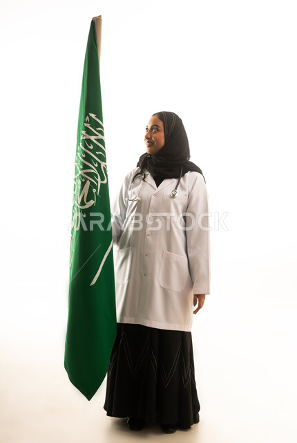طبيبة سعودية ممسكة بعلم المملكة العربية السعودية