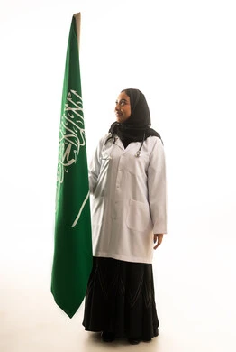 طبيبة سعودية ممسكة بعلم المملكة العربية السعودية