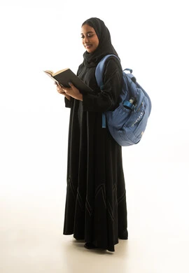 طالبة سعودية تقرأ كتاباً بخلفية بيضاء