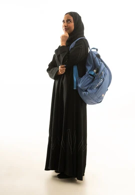 امرأة سعودية بحقيبة ظهر في وضعية تفكير خلفية بيضاء