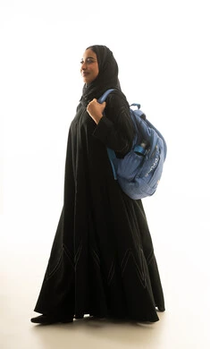 طالبة سعودية بالعباءة مع حقيبة ظهر خلفية بيضاء