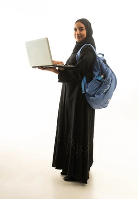 امرأة سعودية تحمل حاسوباً محمولاً وحقيبة ظهر بخلفية بيضاء