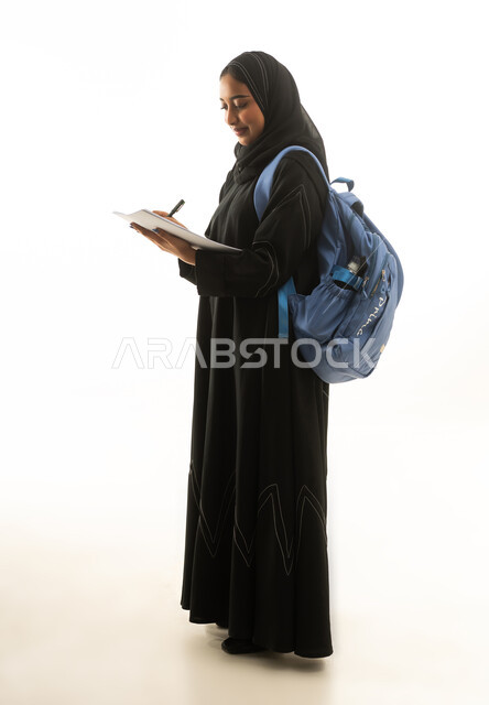 Saudi Female Student Writing with Blue Backpack