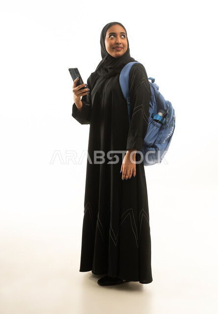 طالبة سعودية مع حقيبة ظهر وهاتف ذكي