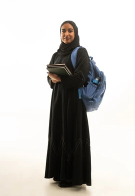 طالبة سعودية مع حقيبة ظهر ودفاتر على خلفية بيضاء