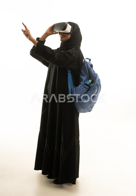امرأة سعودية بالعباءة تستخدم نظارة الواقع الافتراضي