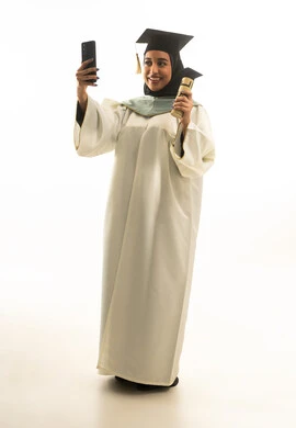 خريجة سعودية تلتقط سيلفي مع شهادة التخرج خلفية بيضاء