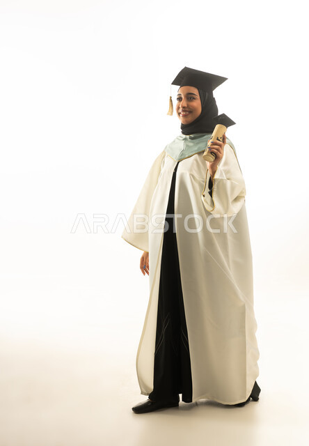 خريجة سعودية بزي التخرج الأبيض تحمل الشهادة