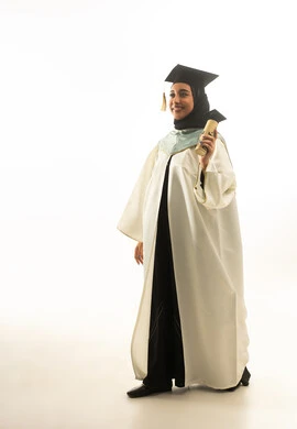 خريجة سعودية بزي التخرج الأبيض تحمل الشهادة