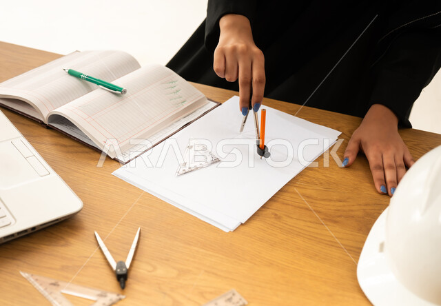 Saudi Female Engineer Drawing Blueprints at Office Desk