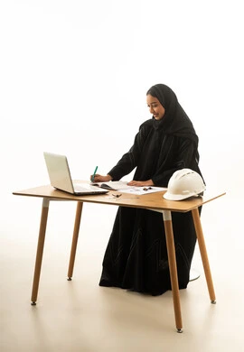 مهندسة سعودية تعمل على مكتب مع كمبيوتر محمول