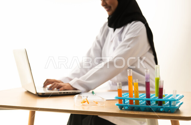 عالمة سعودية تعمل على الكمبيوتر المحمول في المختبر