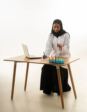 عالمة سعودية وباحثة في مختبر طبي مع أدوات علمية