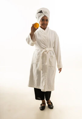 Saudi Woman in White Bathrobe Holding Skin Care Jar
