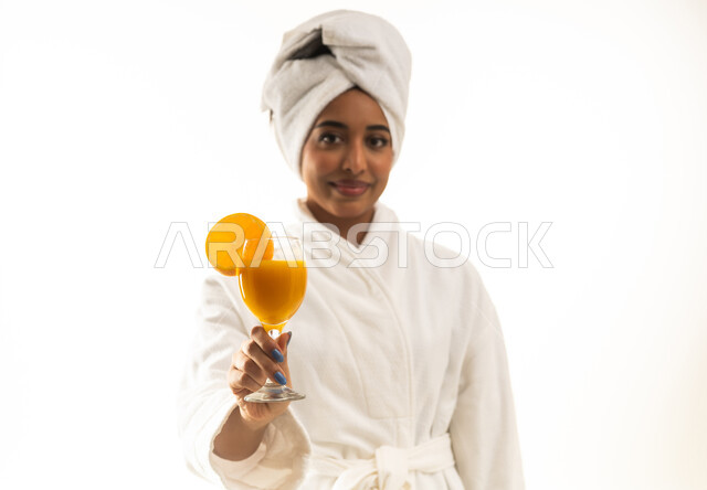 Saudi Woman in White Bathrobe Holding Orange Juice Studio