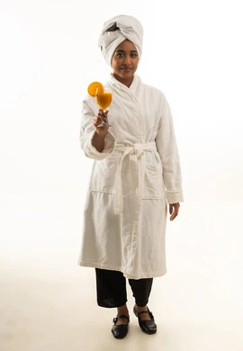 امرأة سعودية برداء حمام أبيض تحمل عصير برتقال