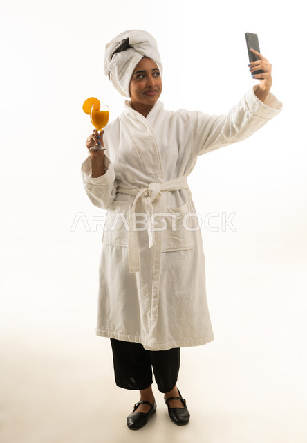 Saudi Woman in White Bathrobe Taking Selfie with Juice