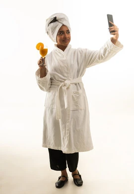 امرأة سعودية برداء الحمام تلتقط سيلفي مع عصير