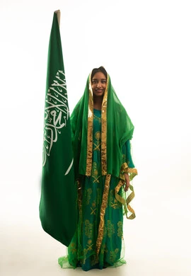 Saudi Woman with National Flag in Traditional Green Dress