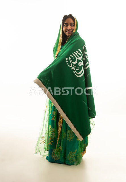 امرأة سعودية بالزي التقليدي ملفوفة بالعلم السعودي