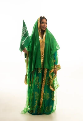 امرأة سعودية بالثوب النشل التقليدي تحمل علم المملكة