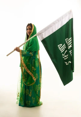 Saudi Woman Holding National Flag in Traditional Dress