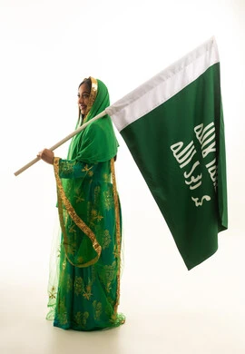 Saudi Woman Holding National Flag in Traditional Dress