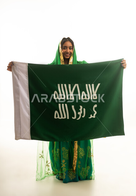امرأة سعودية تحمل العلم الوطني بالزي التقليدي