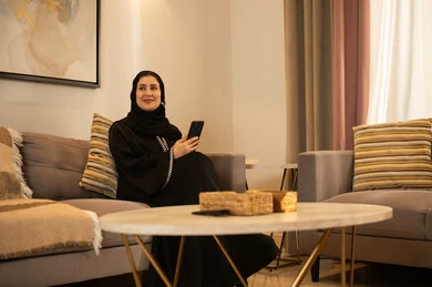 Saudi Woman in Abaya Using Smartphone at Home