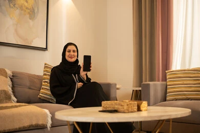 Saudi Woman with Smartphone in Modern Living Room Saudi Woman with Smartphone in Modern Living Room