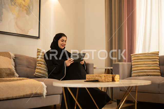 امرأة سعودية تستخدم الجهاز اللوحي في غرفة المعيشة