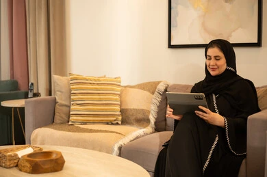 Saudi Woman Using Digital Tablet in Modern Living Room