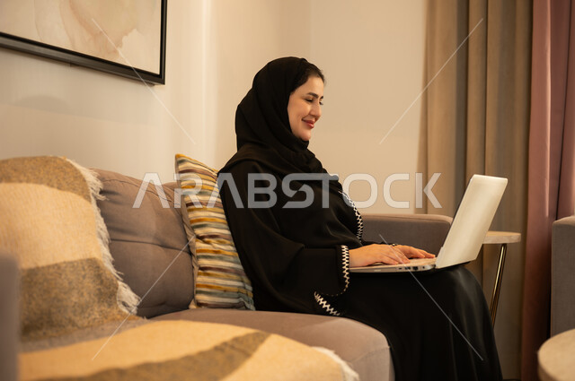 امرأة سعودية تستخدم الكمبيوتر المحمول في المنزل