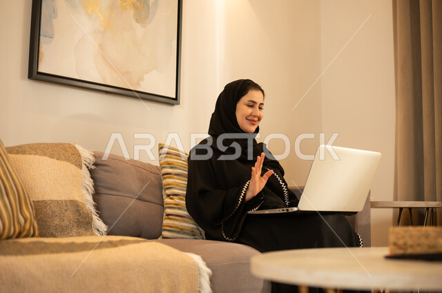 امرأة سعودية تستخدم اللابتوب لمكالمة فيديو في المنزل