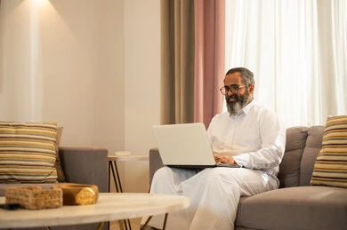 Saudi Man Using Laptop in Modern Living Room