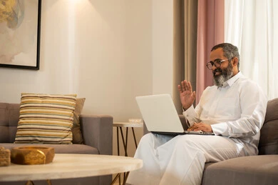 Saudi Man Using Laptop for Video Call at Home