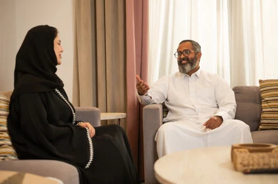 رجل وامرأة سعوديان يتحدثان في غرفة المعيشة